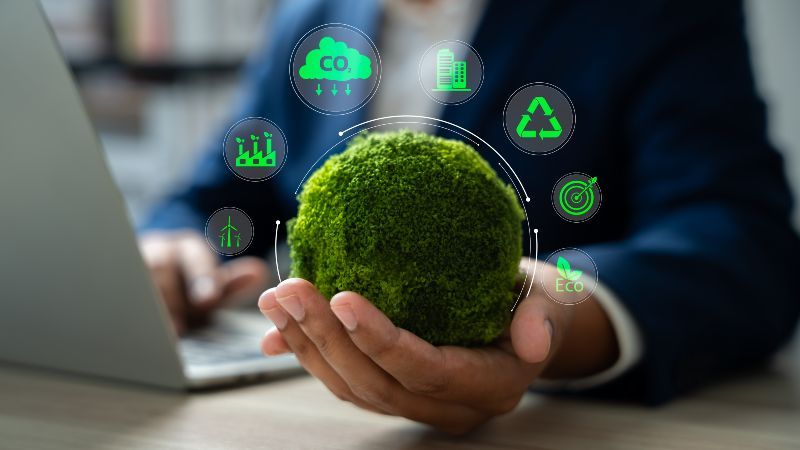 Eine Hand hält eine moosbedeckte Kugel. Darüber schweben sieben Symbole, die zentrale Themen des Umwelt- und Klimaschutzes visualisieren.