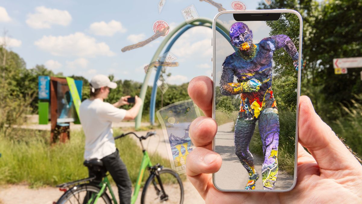 Spielplatz; davor Hand mit Smartphone, auf dessen Bildschirm virtuelle Zusatzinhalte zu sehen sind.