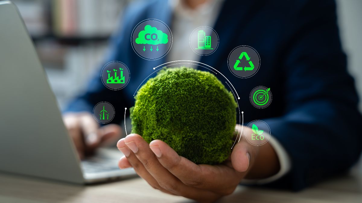 Eine Hand hält eine moosbedeckte Kugel. Darüber schweben sieben Symbole, die zentrale Themen des Umwelt- und Klimaschutzes visualisieren. 